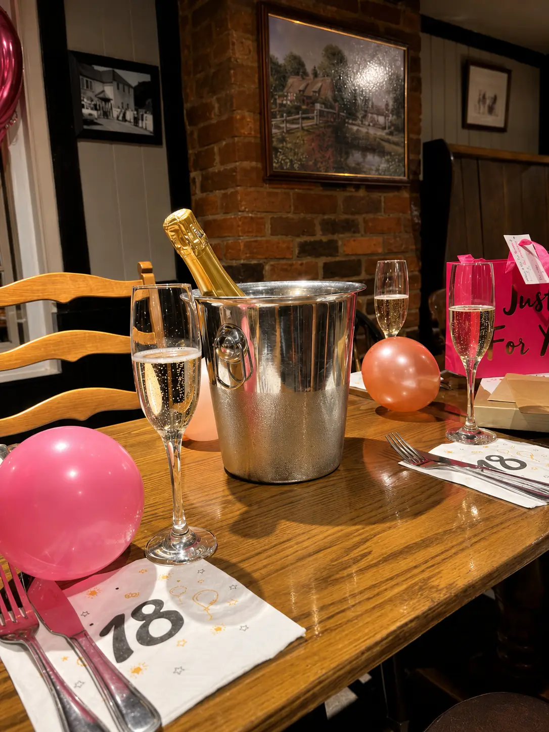 Table set for an 18th birthday with Prosecco on ice, glasses and balloons