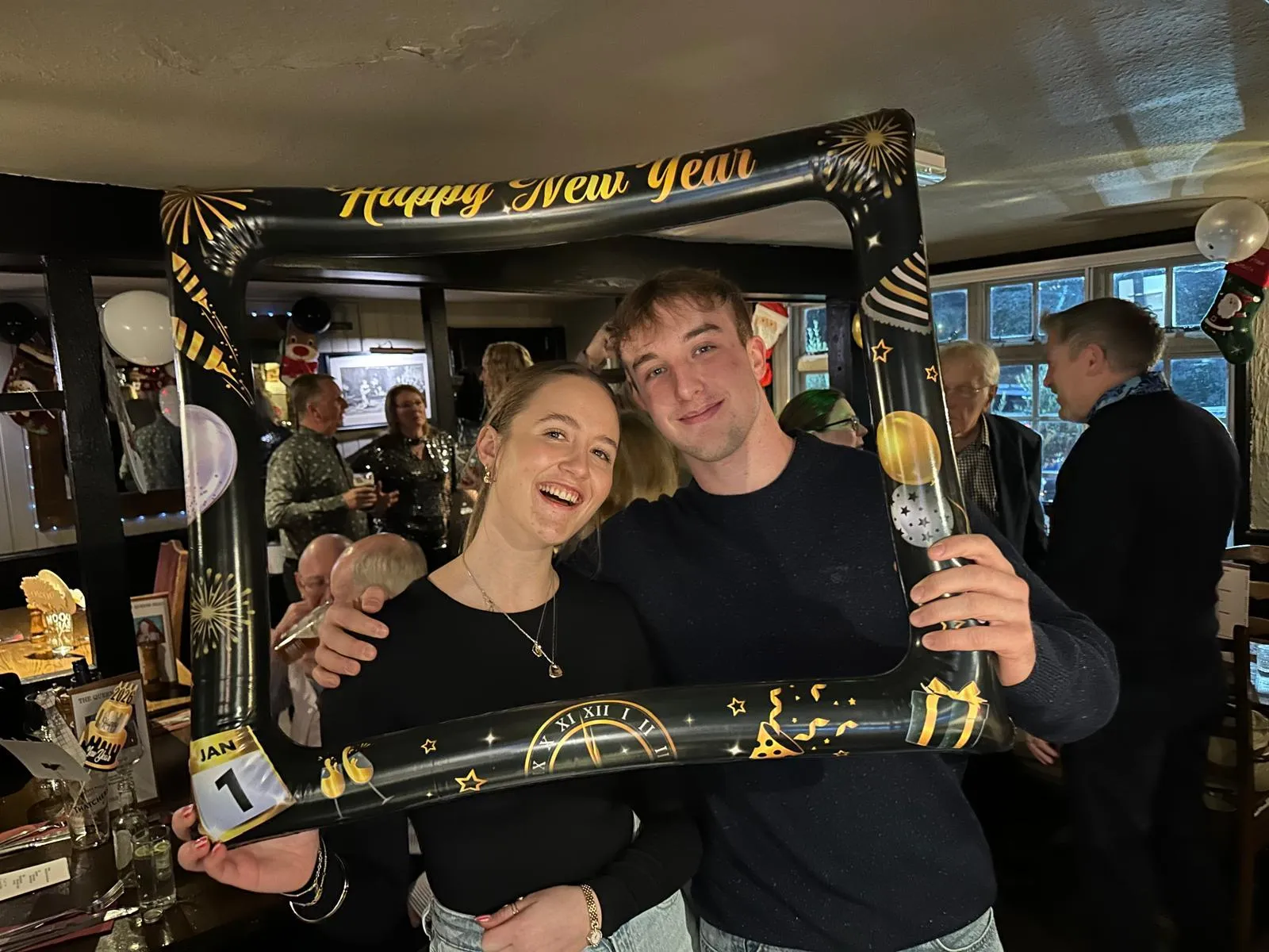 Two guests celebrating in a busy bar full of people